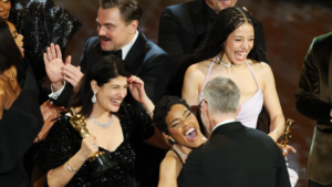 Leonardo DiCaprio (en el centro a la izquierda), Chase Infiniti (en el centro a la derecha), Paul Thomas Anderson (a la derecha) se abrazan mientras la productora Sara Murphy (a la izquierda) y Teyana Taylor (en primer plano en el centro) celebran tras ganar el Óscar a la mejor película por Una batalla tras otra.Foto: Chris Torres/EFE.